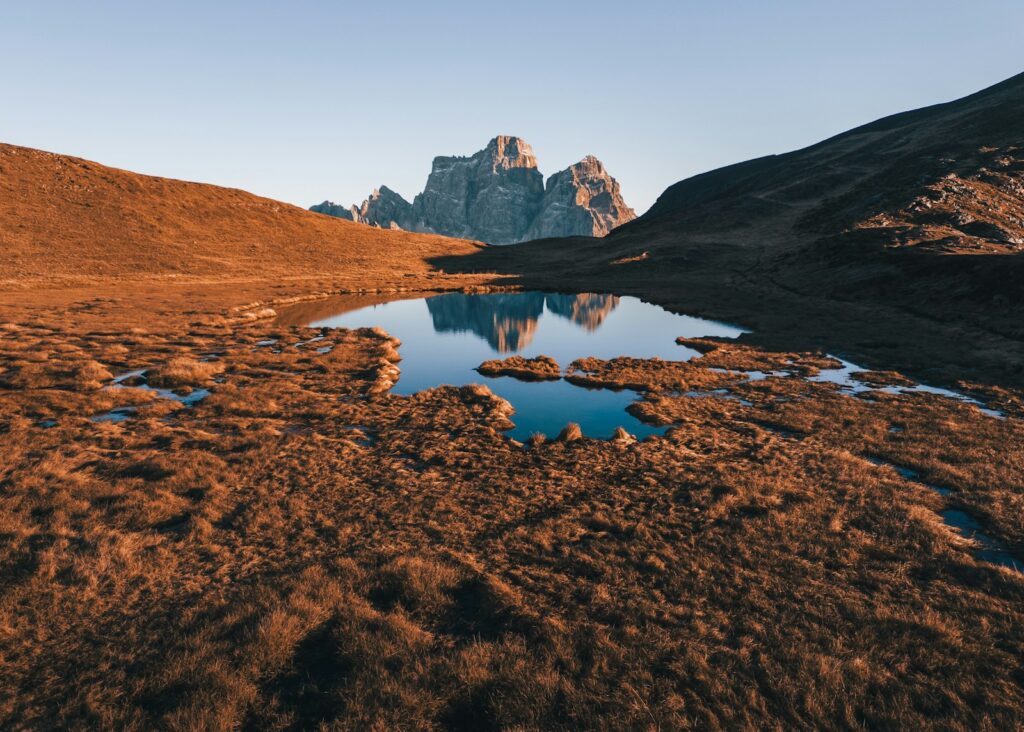 A mountain range with a lake in the foreground